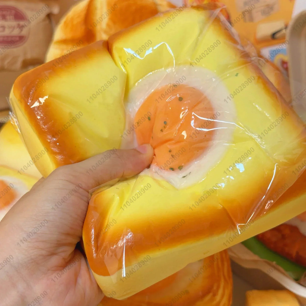 A squishy fried egg toast stress relief toy shaped like a piece of toast with an egg in the center.