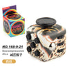 A black fidget cube with a leopard print design and multiple buttons is shown next to its packaging.