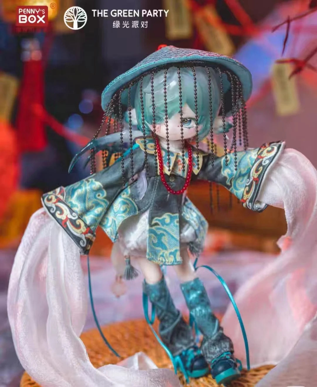 A detailed collectible doll featuring teal hair and clothing, presented in a box set.