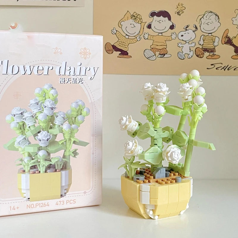 A miniature flower bouquet made of light green and white building blocks displayed next to its packaging.