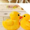 A close-up of two adorable yellow duck plush toys sitting together.
