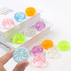 A set of five translucent squishy toys in various colors including yellow, blue, pink, and green, displayed on a white box.