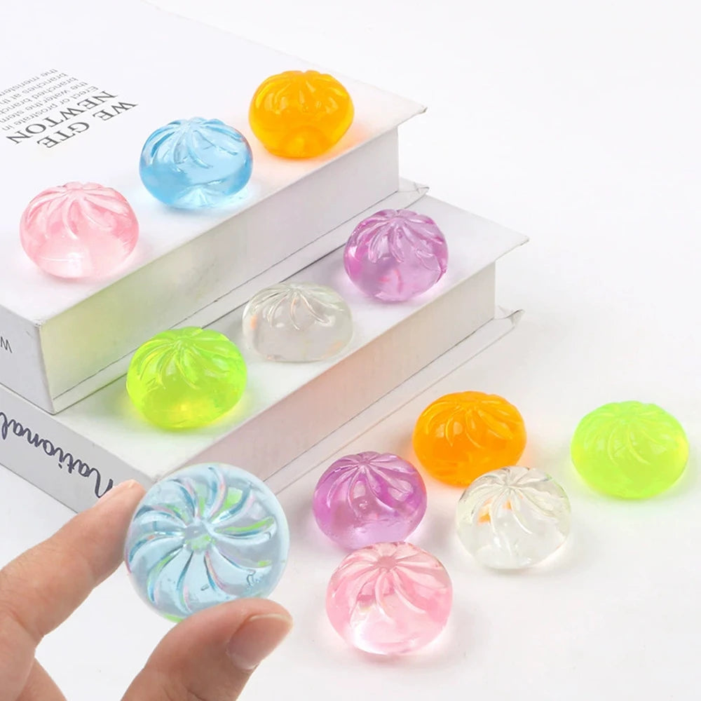A set of five translucent squishy toys in various colors including yellow, blue, pink, and green, displayed on a white box.