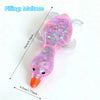A pink squishy duck fidget toy with a translucent body and orange beak, showing its size.