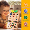 A child is interacting with a wooden Montessori busy board featuring various colorful buttons and switches for sensory activi