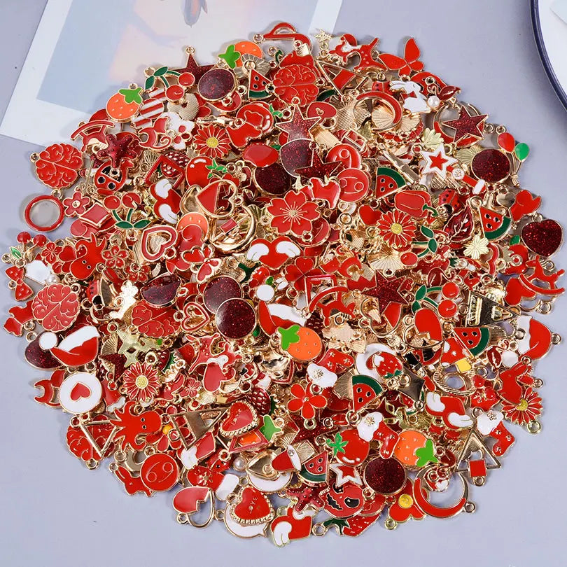 Assorted metal pendants and charms in red, gold, and green for jewelry making