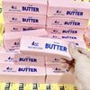 A collection of pink butter squishy stress relief fidget toys packaged in clear plastic.