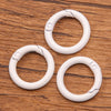 A set of ten white metal O-ring spring clasps arranged on a wooden surface.