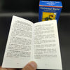A box of Universal Waite Tarot Deck and guide book lying next to an open card, showing the back of a tarot card.