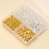 A clear plastic box containing various gold and silver lobster clasps and open jump rings for jewelry making
