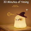 A glowing white silicone lamp shaped like a pumpkin sitting on a book, with a timer displaying 30 minutes.