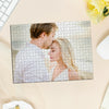 A jigsaw puzzle featuring a portrait of a man and woman, printed on cardboard or wood.
