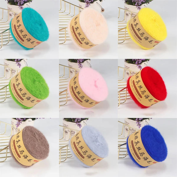 Bolillos de lana de varios colores: verde azulado, rosa, amarillo y rojo, sobre fondo blanco.