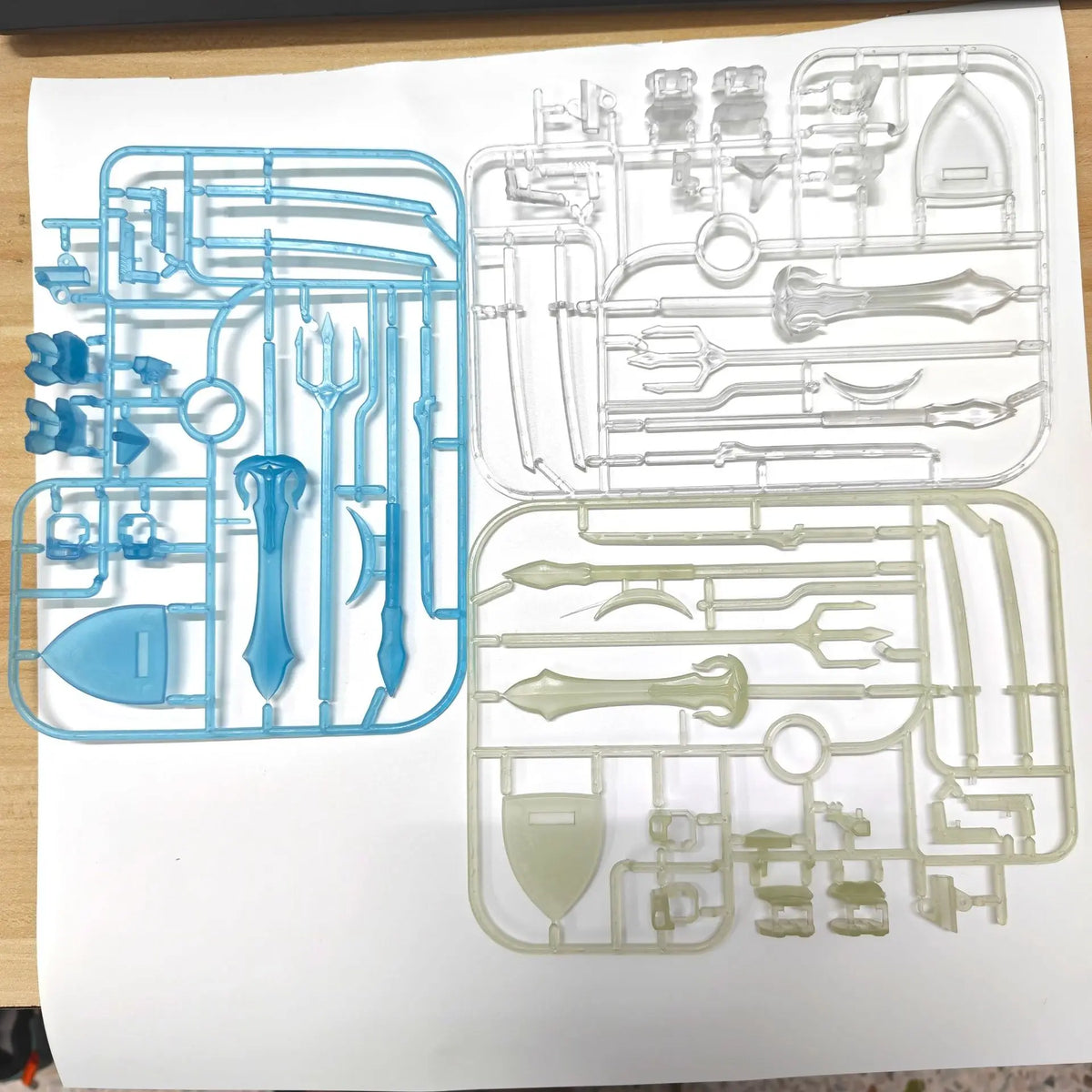 A collection of clear plastic magnetic tools and components for building action figures displayed on a white background.