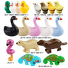 A collection of marine animal building blocks including a black duck, pink swan, white whale, yellow duck, and green shark.