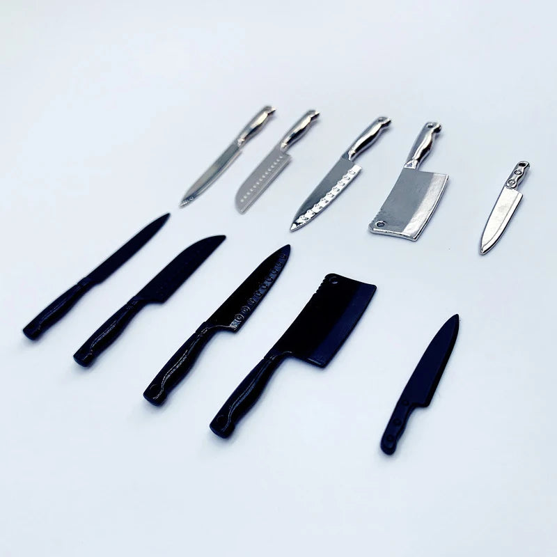 A collection of miniature metal kitchen knives with various blade shapes and handles arranged on a white background.
