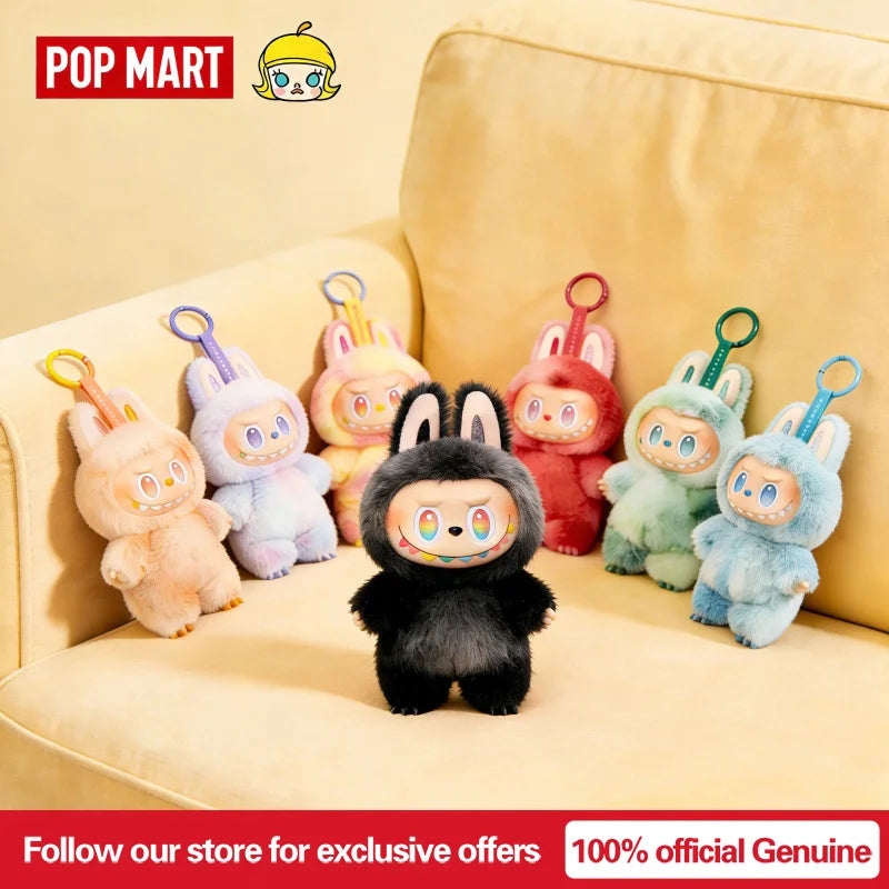 A collection of Labubu vinyl plush pendants and blind box toys displayed on a light yellow sofa.