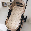 Un matelas en coton doux beige pour poussette de bébé.