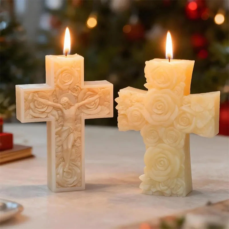 Two glowing white floral cross candles on a surface.