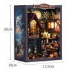 A wooden miniature dollhouse kit featuring a witch's house scene with detailed furniture and LED lighting.
