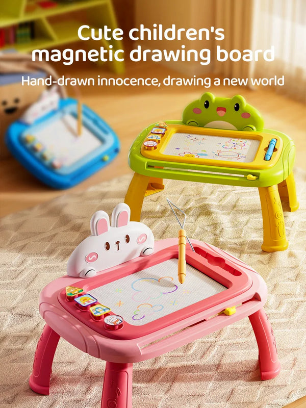A pink magnetic drawing board for children with various tools and a green plastic animal on a wooden surface.