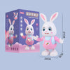 A pink rabbit-shaped musical robot toy with large ears and expressive eyes, packaged in a box.