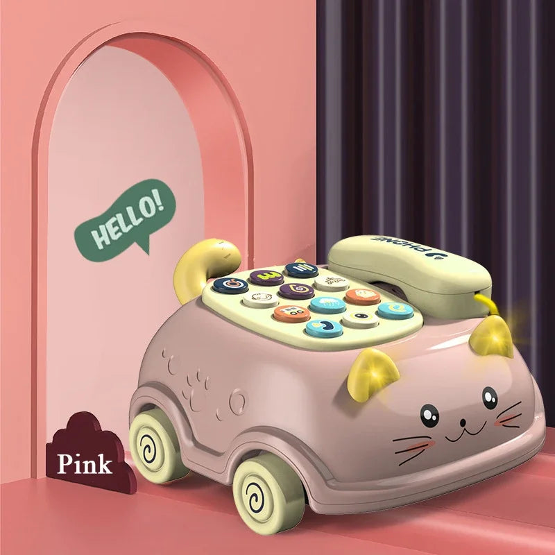 A pink cat-shaped musical phone toy for toddlers with lights and sounds sitting on a surface.