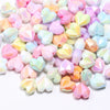 A pile of colorful, iridescent heart-shaped acrylic beads for jewelry making.