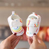 A pair of cute bear soft sole sandals for baby's first steps, featuring white fabric with colorful stripes and stars.