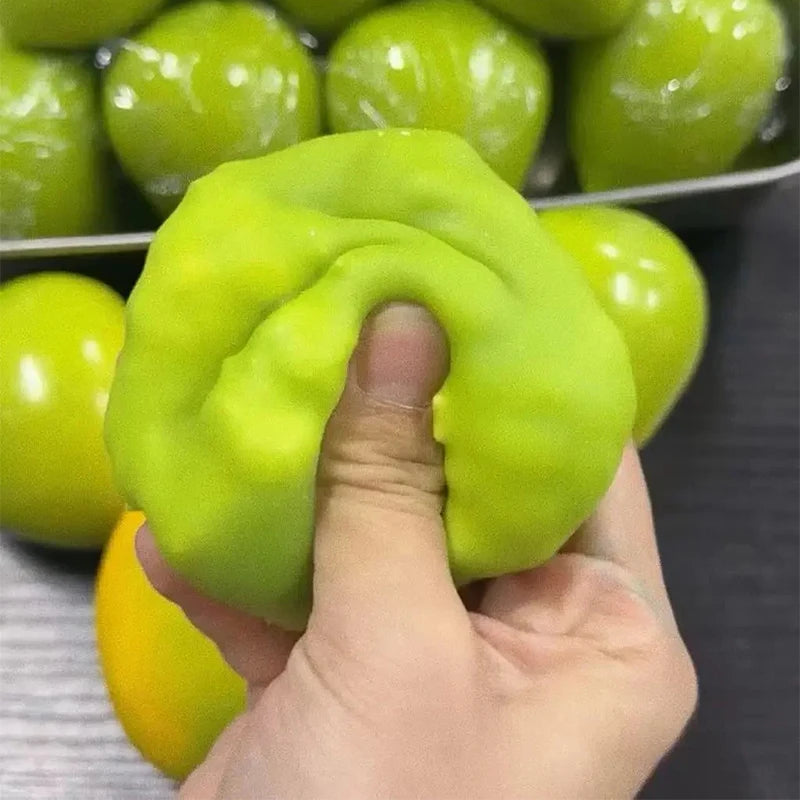 A hand holds a bright lime green, textured stress ball with a yellow accent.