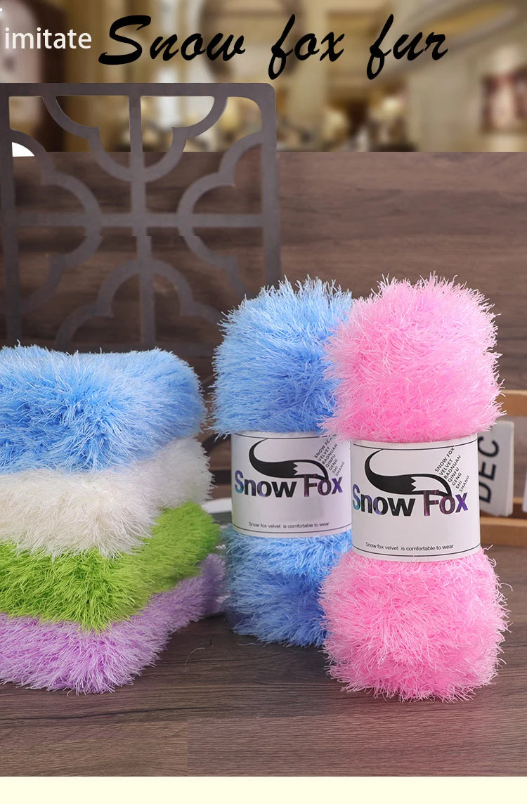 A collection of fluffy faux fur yarn in blue, white, green, and pink colors displayed on a wooden surface.