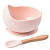 A pink BPA-free silicone snack cup with a lid is shown next to a wooden spoon.