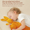 A young child is gently holding an orange stuffed animal while sleeping on a light-colored surface.