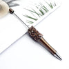 A close-up of a diamond sequins bead ballpoint pen with a gold tip resting on a white background.