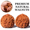 Two halves of premium natural walnuts showing the textured, brown shell.