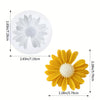 Un moule en silicone d'une marguerite jaune avec un centre blanc, à côté de la fleur finie.