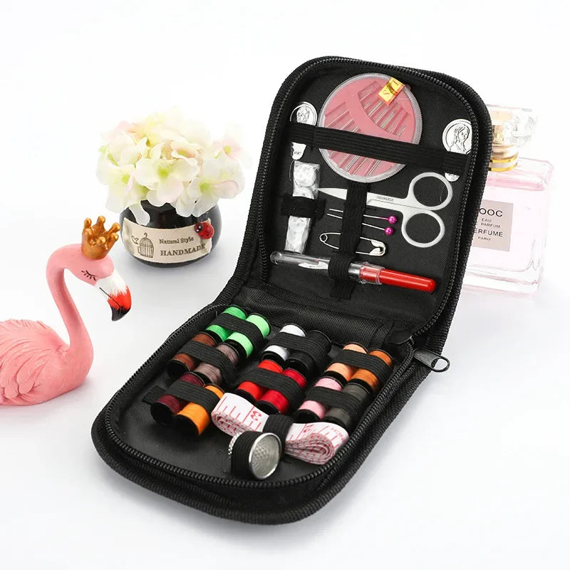 A black travel storage box containing a complete sewing kit with scissors, needles, and various tools.