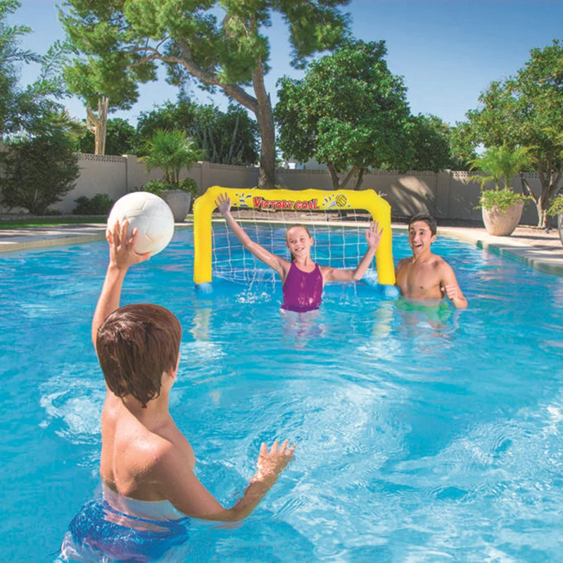 Three people playing water volleyball in a pool with a yellow net and ball.