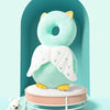 A light blue soft baby head protector pillow with white adjustable straps is displayed in a teal arched frame.