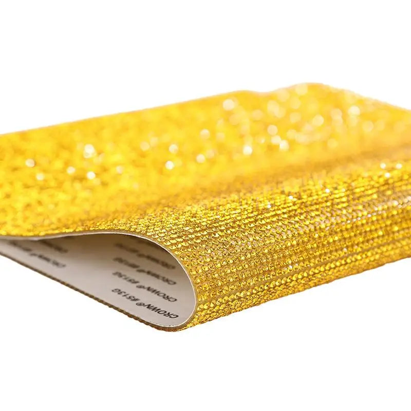 A roll of sparkling gold rhinestone adhesive tape for DIY crafts and decor.