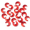 A collection of red glass beads shaped like the moon for DIY jewelry making