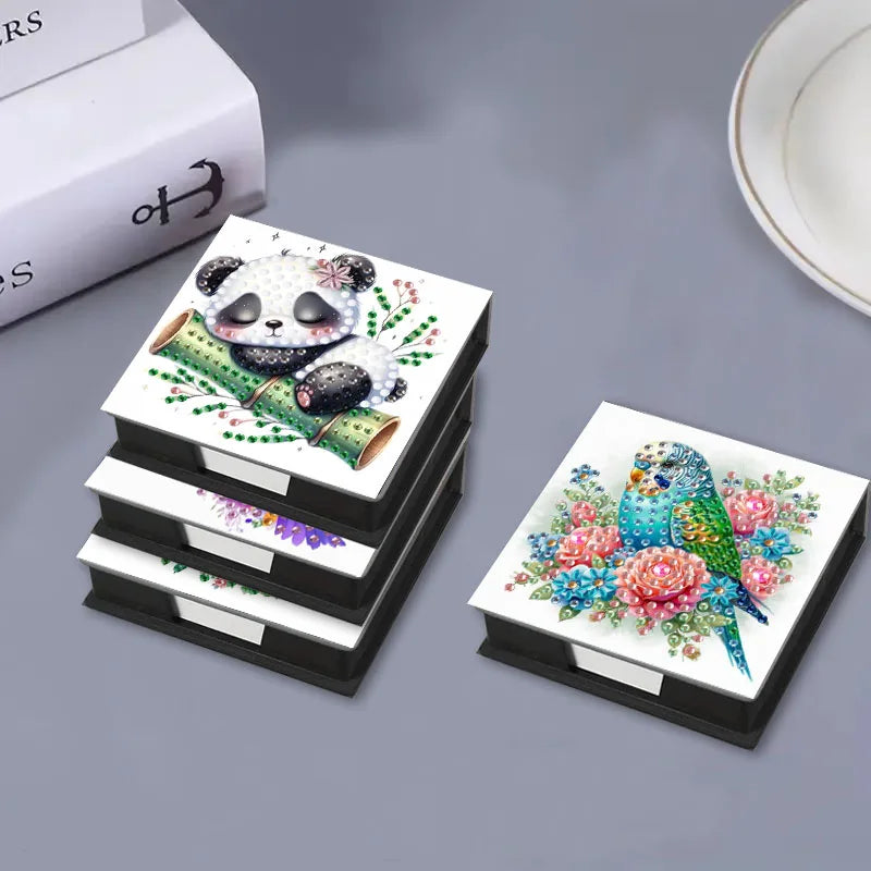 A DIY diamond painting kit featuring a panda and a bird pattern with gemstones and storage boxes.