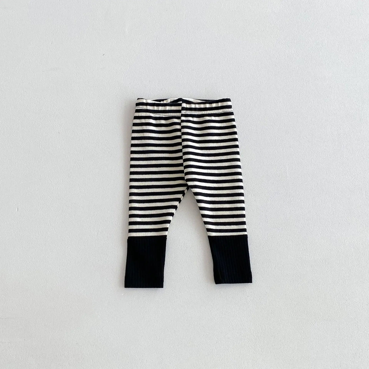 Black and white striped baby leggings with a solid black cuff design