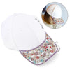 White baseball cap with a decorative, multicolored crystal glass sunflower claw rhinestone trim.