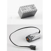 A gray technical power functions motor set for building blocks with a black wire and a small electronic component.