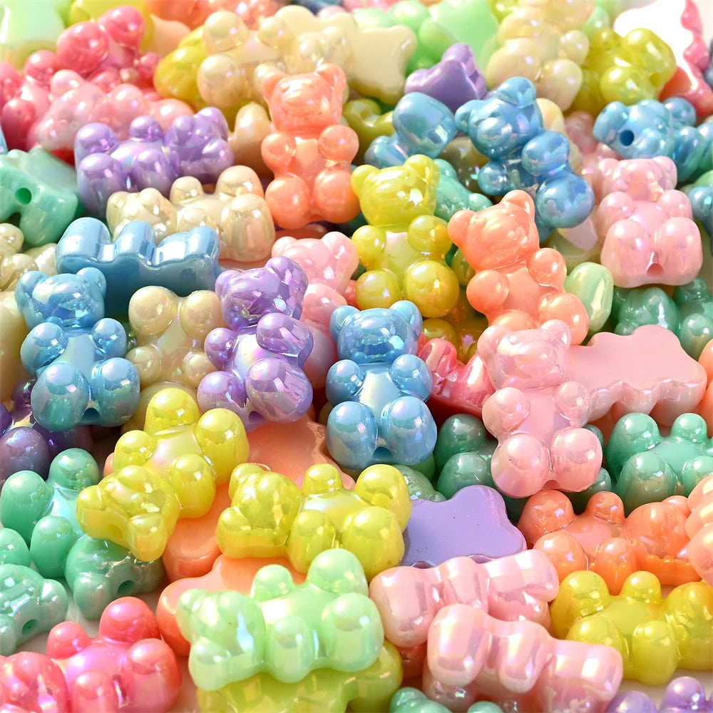 A close-up of colorful pastel bear-shaped acrylic craft beads with a shimmering finish.