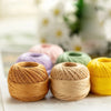 A close-up of various spools of natural colored cotton crochet thread for tatting and embroidery.
