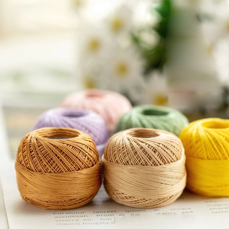 A close-up of various spools of natural colored cotton crochet thread for tatting and embroidery.