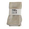 A stack of beige cotton-linen dinner napkins with a white label featuring kitchen utensils.