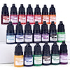 A collection of liquid candle and soap colorants in various shades including red, purple, orange, pink, and green bottles.